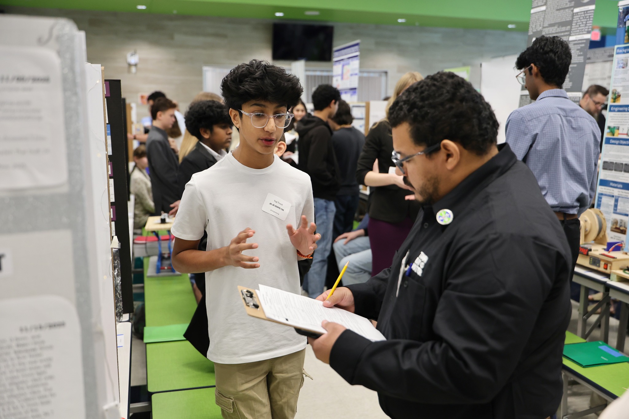 student explaining project - <p>Congratulations to all of our students who participated and thank you to the organizers and judges!</p>